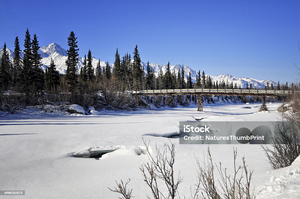 Bridge Over Frozen Water Warmer weather has started to melt the ice on this river near the Matanuska Glacier in Alaska. Alaska - US State Stock Photo