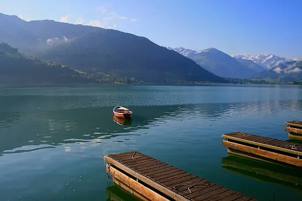 Warm Sunrise in Zeller lake jetty pier and boat, Zell am See, Austria.