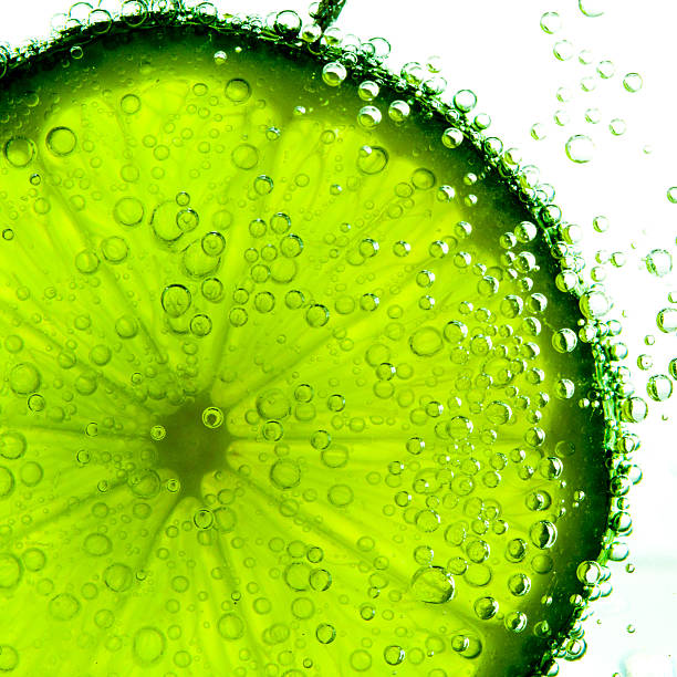 citron vert avec des bulles isolé sur blanc - lemon textured peel portion photos et images de collection