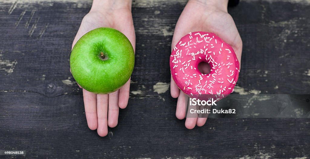 Choisir entre apple et beignet - Photo de Hygiène alimentaire libre de droits