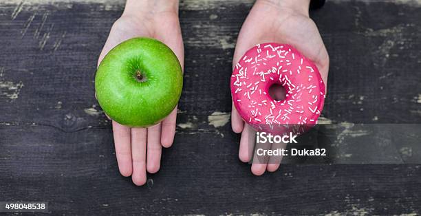 Photo libre de droit de Choisir Entre Apple Et Beignet banque d'images et plus d'images libres de droit de Hygiène alimentaire - Hygiène alimentaire, Choix, Alimentation lourde