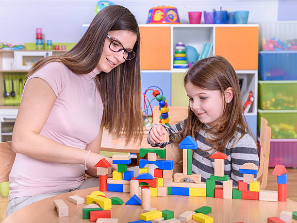 istock Kindergarten Teacher Helping Child in Creative Activities 498049742