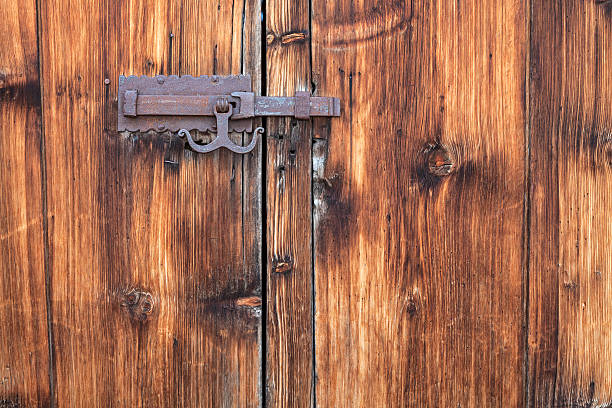 Weathered wooden door with door latch in Tschlin (Graubunden Canton, Switzerland).