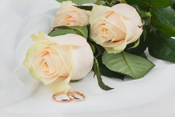 istock Wedding rings and flowers on silk 498050074