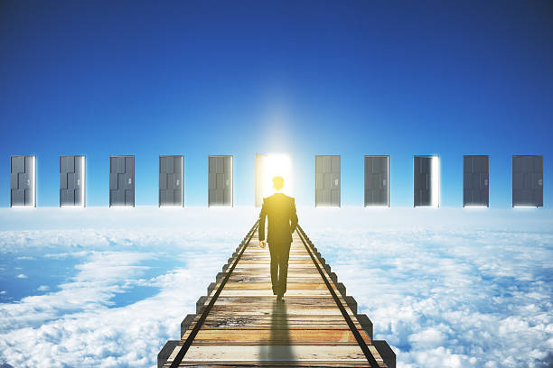 istock Man walking to an open door in clouds concept 498050480