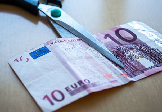 istock Scissors Cutting a Ten Euro (EUR) Banknote Close Up 498051252