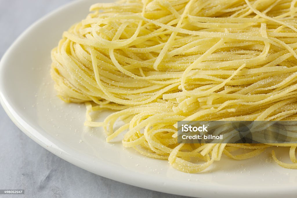 Fresh uncooked massa linguine sobre prato branco - Foto de stock de Linguini royalty-free