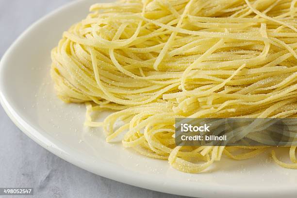 Foto de Fresh Uncooked Massa Linguine Sobre Prato Branco e mais fotos de stock de Linguini - Linguini, Alimentação Saudável, Amarelo