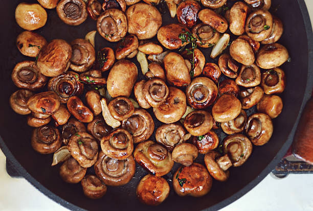 istock Roasted mushrooms champignons with thyme and garlic in a pan 498053875