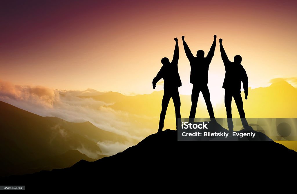 Silhouettes of team Silhouettes of team on mountain peak. Sport and active life concept Group Of People Stock Photo