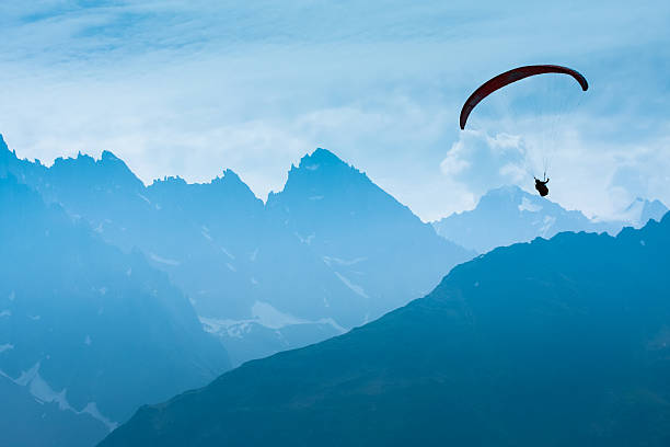 Paraglide shadow figure over Alps peaks