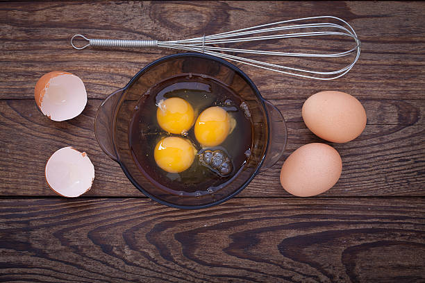istock Raw eggs in bowl for whipping on wooden. Baking ingredients 498055172
