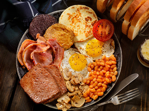 Full Traditional Scottish Breakfast Sunny side up Eggs with Haggis,Blood Pudding, Sausage, Bacon, Beans, Mushrooms, Toast and Tomatoes-Photographed on Hasselblad H3D-39mb Camera scottish culture stock pictures, royalty-free photos & images