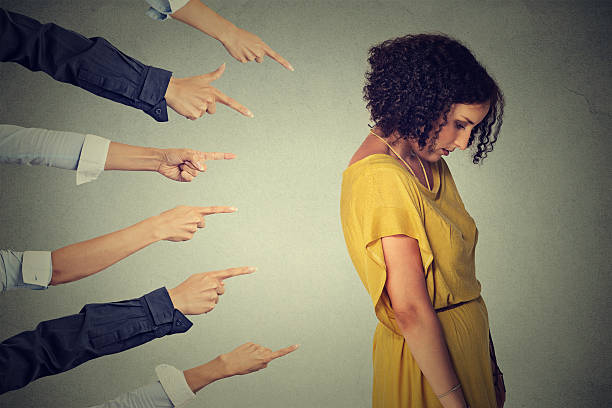 istock Accusation. Sad woman looking down fingers pointing at her 498057692