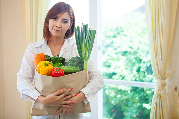 istock Young Woman with vegetables in shopping bag 498062105