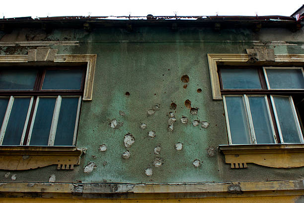 Scars of war in Mostar A bullet riddled builing in downtown Mostar, Bosnia. guerrilla warfare photos stock pictures, royalty-free photos & images