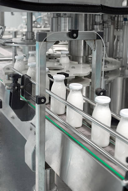 glas-flaschen auf dem förderband - milk industry milk bottle factory stock-fotos und bilder