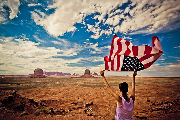 istock Woman Holding US Flag at Monument Valley 498063967