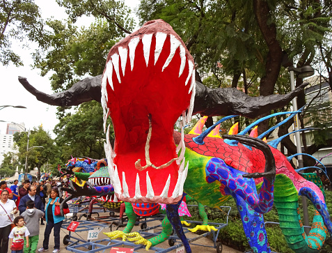 Mexico City, Mexico-October 24, 2015:  This bull dinosaur was spotted at and outdoor art exhibit in Mexico City open to the public.  This is one of many colorful animals that can be seen.  Mexico City has many activities like this one that people can enjoy.  People in the background are looking at the colorful animals.