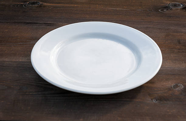 istock White plate on wood desk 498066885