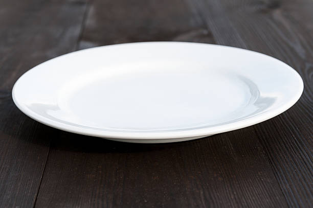 istock White plate on wood desk 498066887