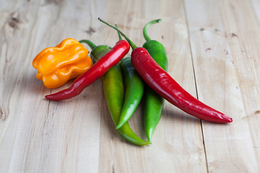 mix of hottest peppers on wooden table