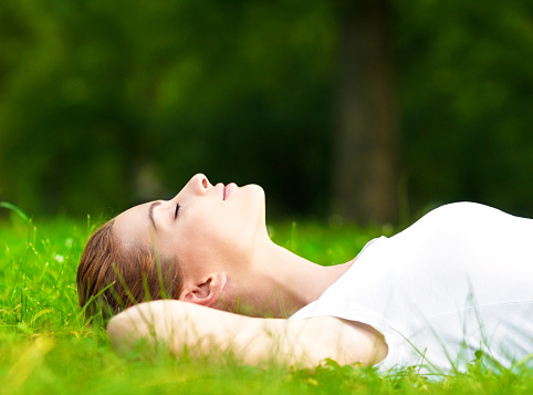 woman lying on grass and relaxing in park.