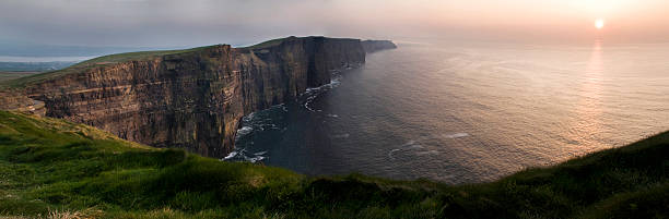 klippen von moher bei sonnenuntergang-irland - republic of ireland cliffs of moher panoramic cliff stock-fotos und bilder