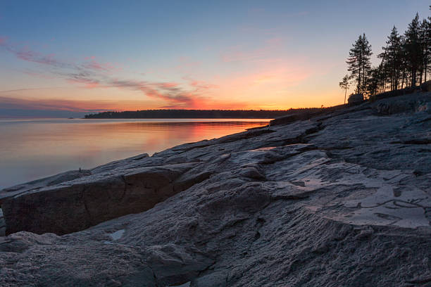 istock Lake granite shore with ancient petroglyphs aginst bright sunset background 498091549