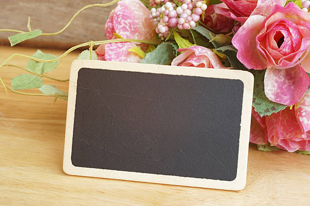 istock grunge wood blackboard in front of artificial roses bouquet 498094178