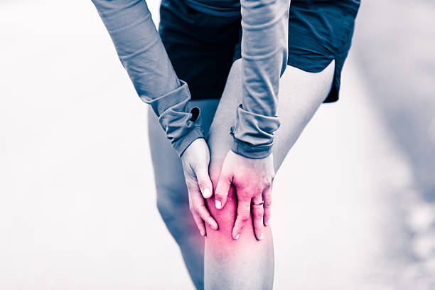 Knee pain, woman holding sore and painful leg stock photo