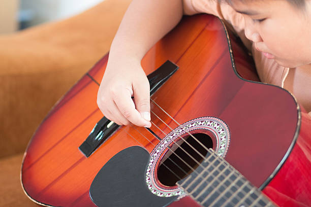 istock Boy playing a acoustic guitar on in black and white 498098654