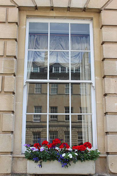 istock Window box with red Geranium flowers (pelargoniums) on Georgian house 498101347