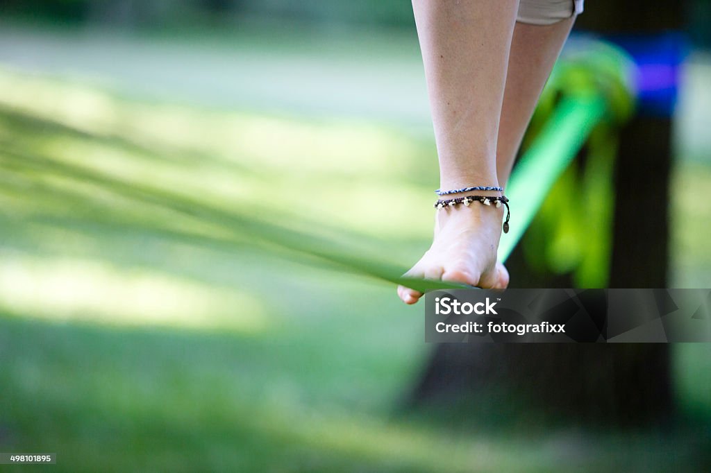 Młoda kobieta w parku na slackline równoważenie - Zbiór zdjęć royalty-free (Równowaga)