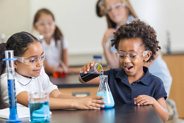 istock Little girls doing experiment with chemistry set in science classroom 498101925