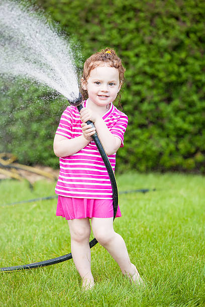 istock Girl Spraying With Garden Hose 498102131