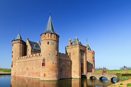 Muiden, The Netherlands - March 26, 2012: Castle The Muiderslot with moat in Muiden, The Netherlands,  a popular tourist destination, on March 26, 2012