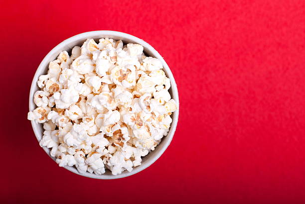 istock box of popcorn on a red background, top view 498102848
