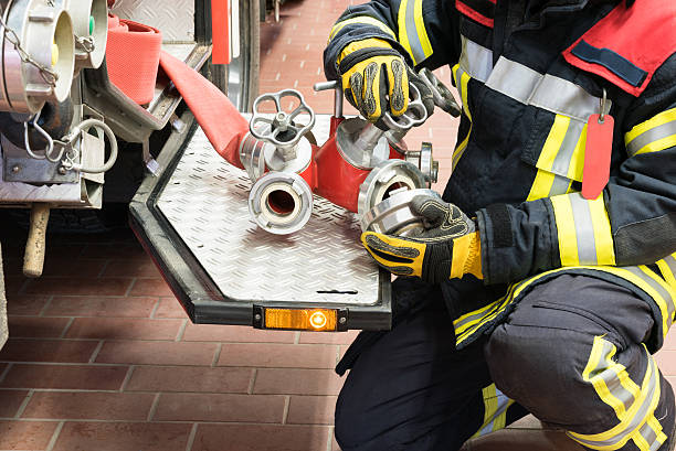 fireman en acción conectado de una manguera para incendios - action fire department car men fotografías e imágenes de stock