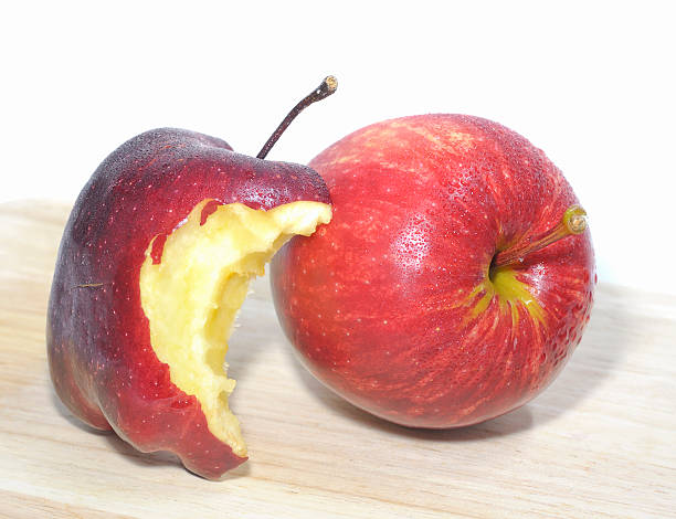 istock Red bitten apple isolated on wooden base 498103399