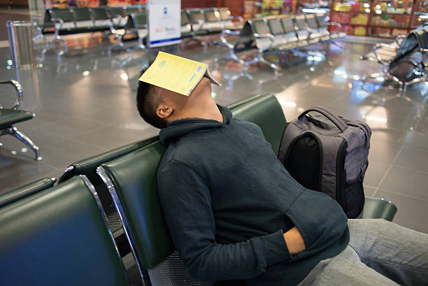 istock Waiting alone in the empty airport with book on face 498111976