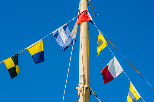 Signal flag flying from a yellow ship mast.