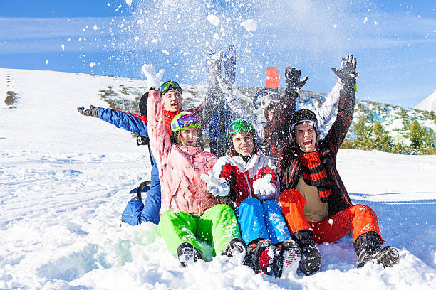 istock Funny happy friends with snowboards throwing snow 498115397