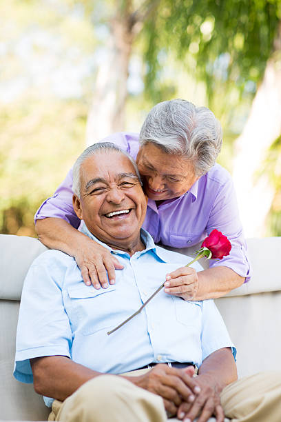 istock Senior wife with rose hugging husband 498115825