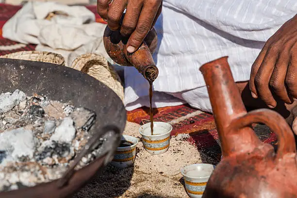 Marsa Alam, Red Sea/ Egypt OCTOBER 31: Unidentified Bedouin young man from Bishari Tribe pouring fresh Bedouin coffee called gabana in a cup, in Characters of Egypt festival 2015.