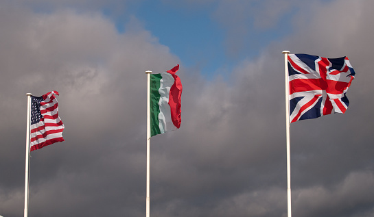 UK, US and Italian Flags flying in a stiff breeze