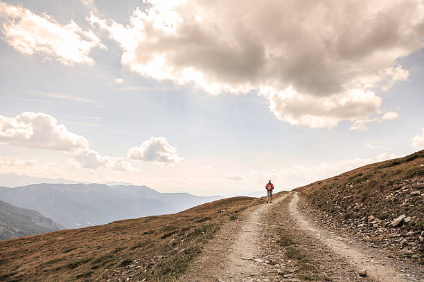 istock walking in solitude - female hiker before mountains scenery 498116762