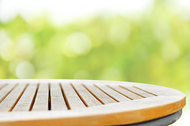 istock Round wood table top on bokeh green background 498120488