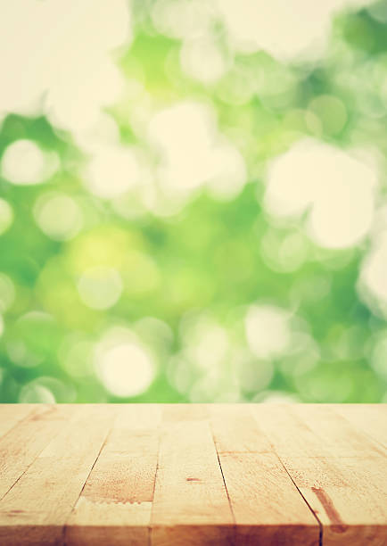 istock Wood table top on blur bokeh green background, vintage tone 498121518