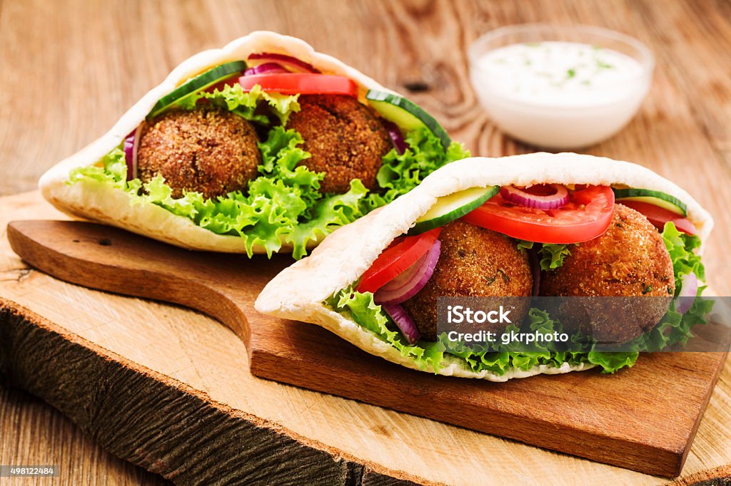 Falafel and fresh vegetables in pita bread on wooden table Egypt Stock Photo